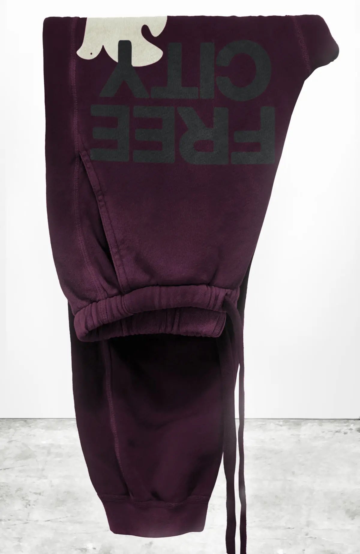 Unisex SUPERFLUFF LUX pocket sweatpant in eggplant with classic black "FREECITYLARGE" print with cream "FREECITYDOVE," covered elastic waist-band with pull drawcord, slant hip pockets and patch back pocket.