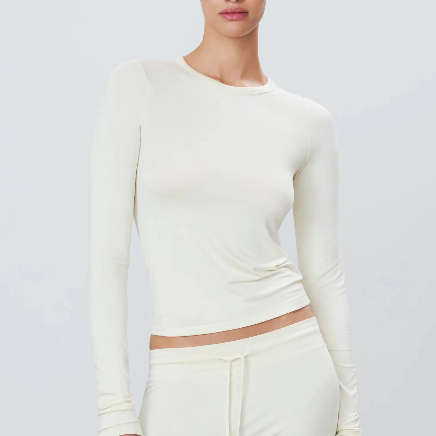 Woman wearing cream long sleeve eterne fitted t-shirt