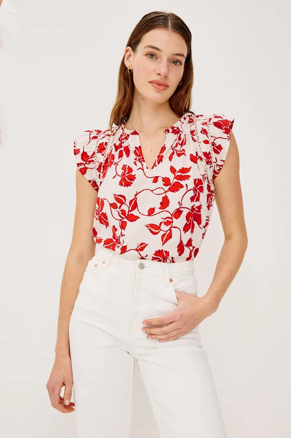 Woman wearing white and red floral blouse with white pants
