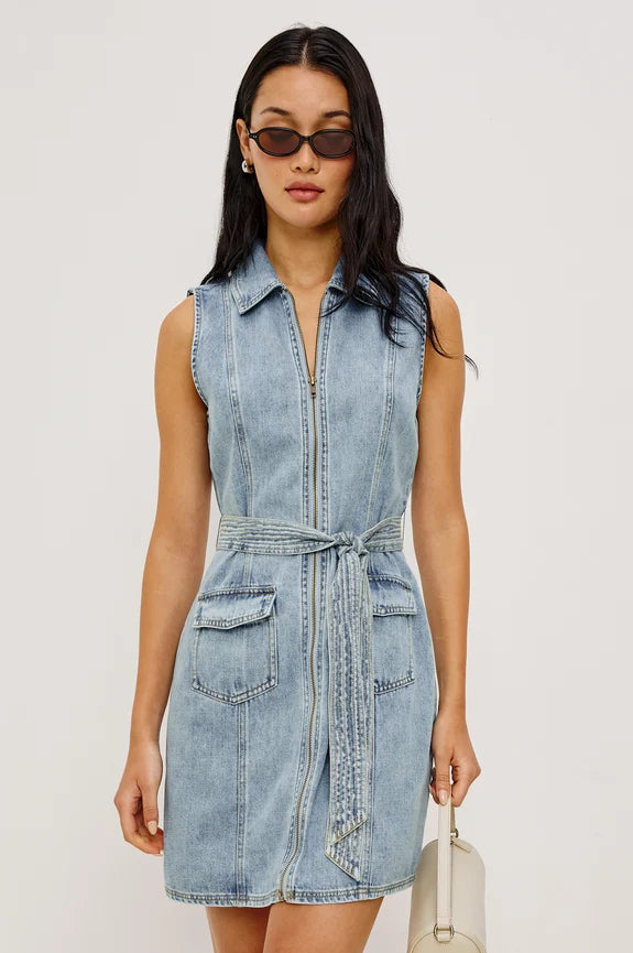 Woman wearing sleeveless denim dress with front zipper, tie and a collar