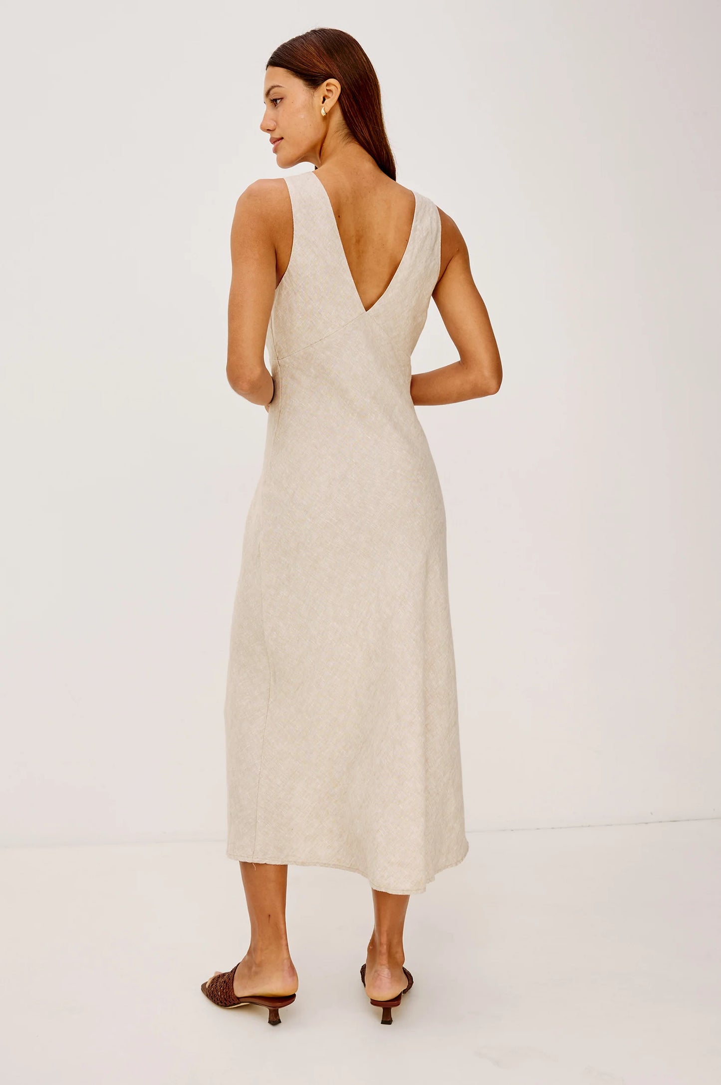 The Avianna is a sleeveless, bias-cut midi dress in softly structured linen with a plunging V-neckline