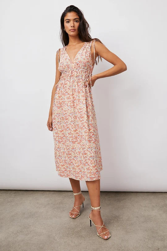 Woman wearing peachy floral tank midi dress and white strappy heel sandals