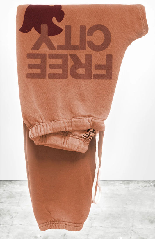 Unisex FLOW sweatpant in canyon with classic "FREECITY" print in rust and dark cherry "FREECITYDOVE," covered elastic waist and pull drawcord.