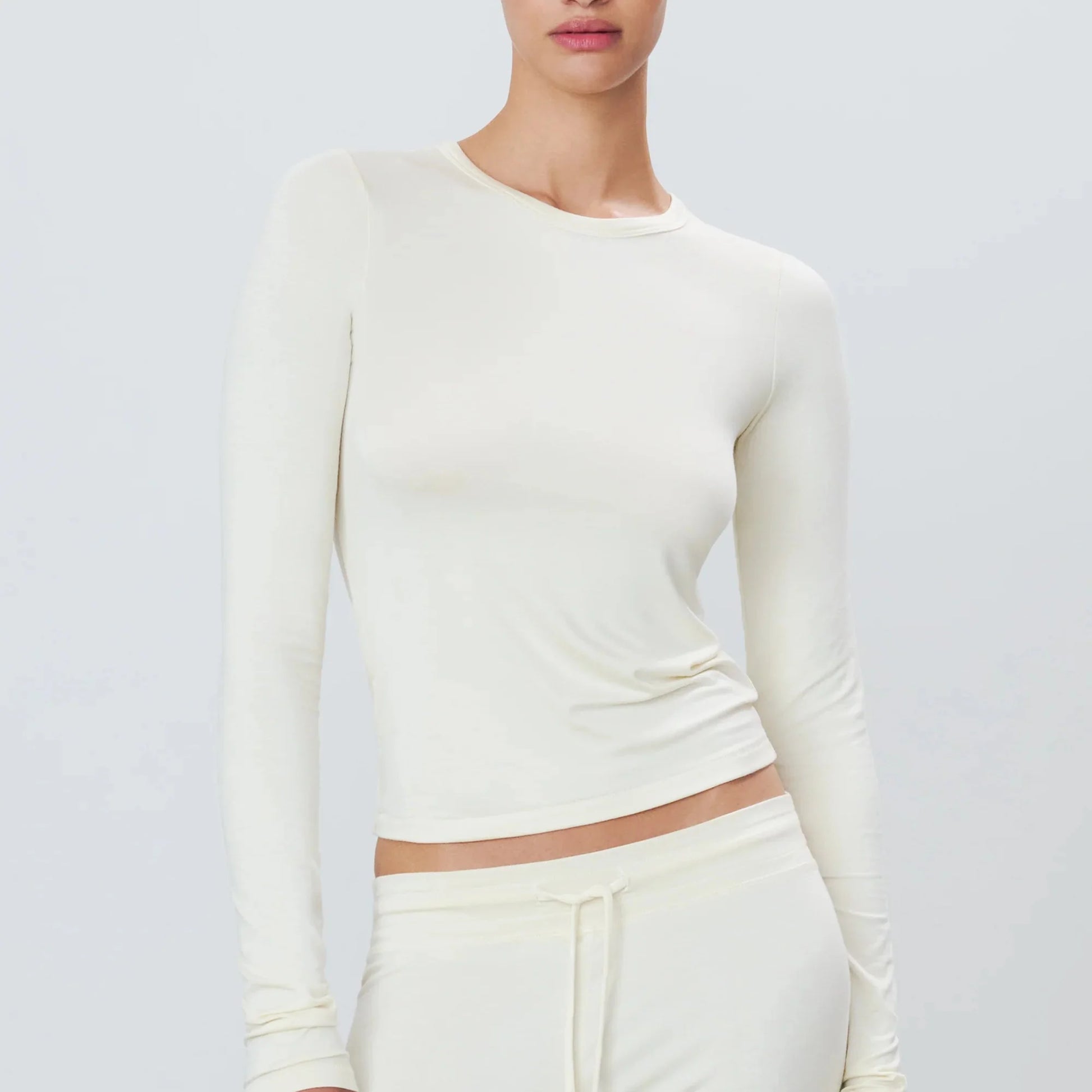 Woman wearing cream long sleeve eterne fitted t-shirt