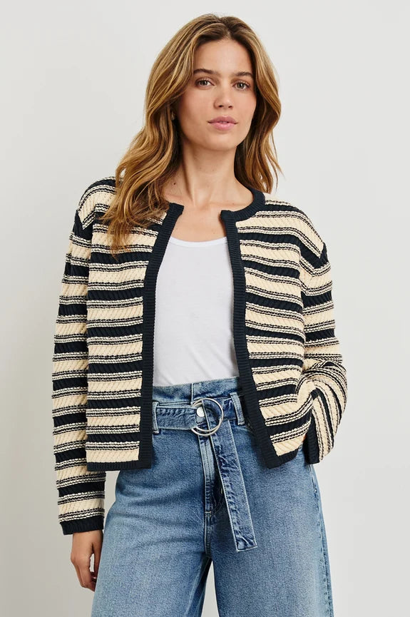 Woman wearing navy and beige striped cadigan with white tank top and jeans