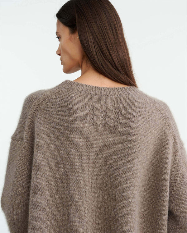 Chunky weight, oversized boxy sweater in Italian air spun cashmere. Regular body and sleeve length. Dropped shoulder. Rib start at hem and sleeve. Single layer rib at neck. Fashioning along arm hole. Signature center back cable knit detail.