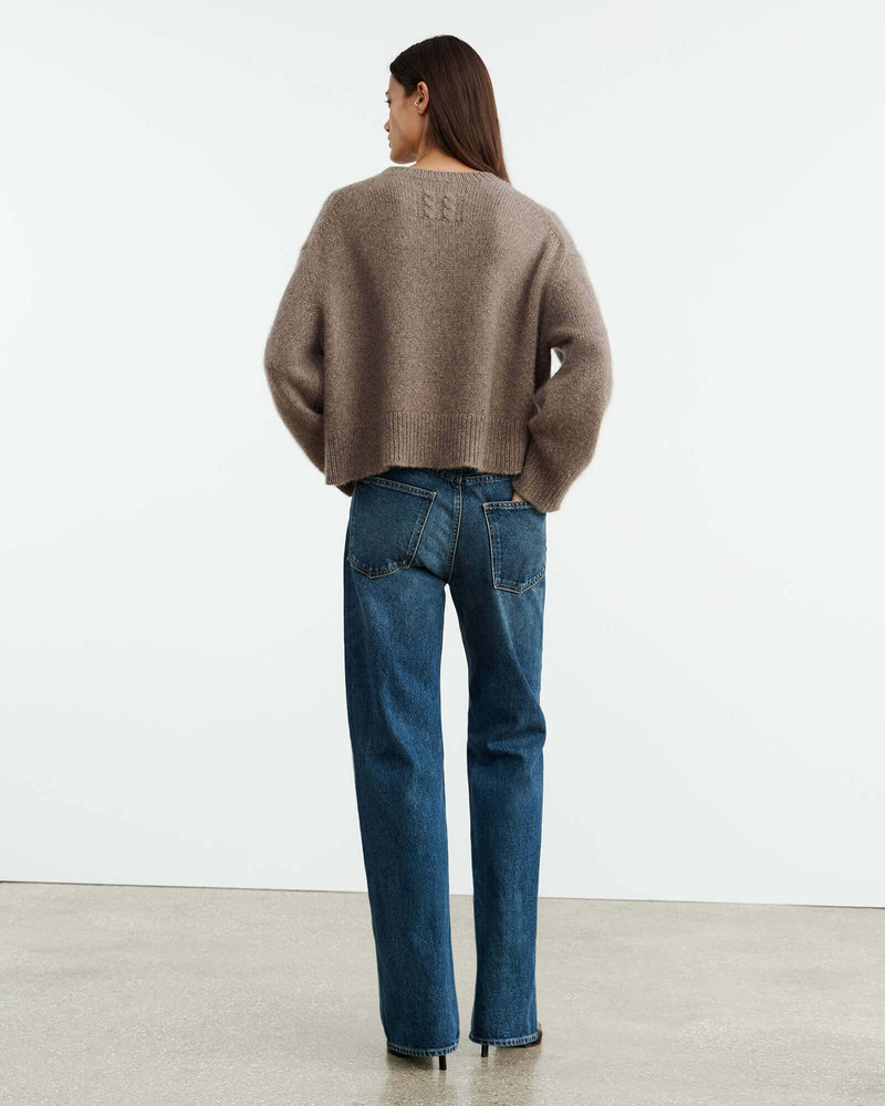 Chunky weight, oversized boxy sweater in Italian air spun cashmere. Regular body and sleeve length. Dropped shoulder. Rib start at hem and sleeve. Single layer rib at neck. Fashioning along arm hole. Signature center back cable knit detail.