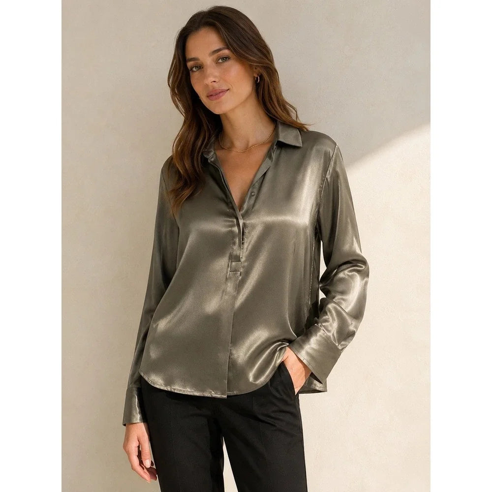 Woman wearing silver collared satin blouse and black pants