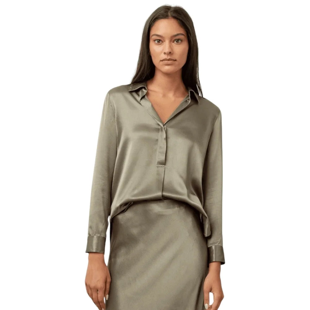 Woman wearing silver collared top and silver silk skirt