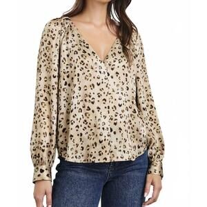 Woman wearing a beige leopard print blouse and jeans 