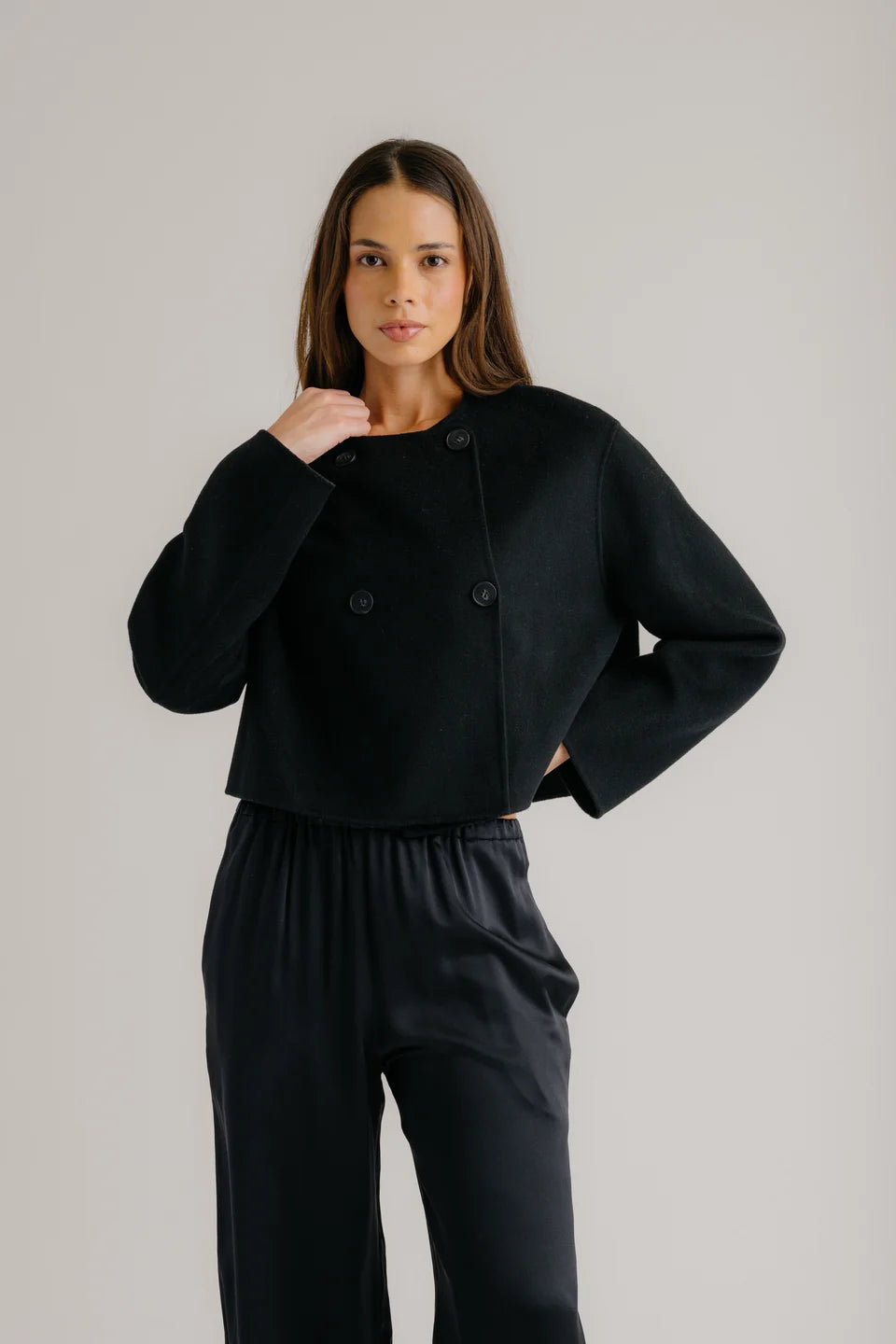 Brunette wearing cropped black double breasted Floren Jacket from SABLYN