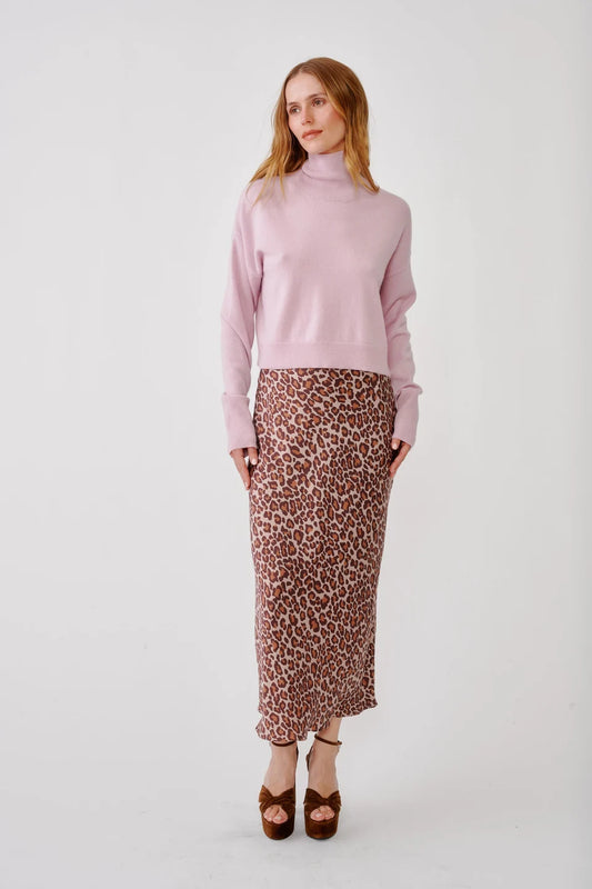 Woman wearing leopard print skirt and pink turtle neck