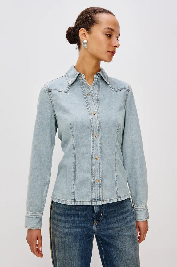 Woman wearing western style denim button up long sleeve shirt and silver earrings with jeans