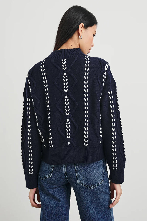 The Tori is an elevated take on the cable sweater, crafted from a heavy wool blend with a white contrast ribbon stitch, ribbed mock neck, and boxy fit.