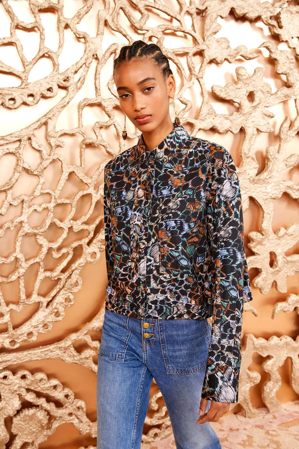 The Aria Blouse is defined by Ulla's swirling feather print with orange, green, and blue tones that come alive against our signature poplin. This vibrant shirt has a classic collar, long sleeves, and a minimal shape with a slightly cropped and boxy fit. 