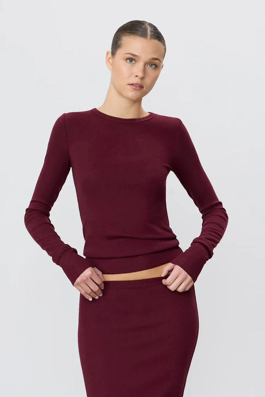 woman wearing oxblood colored long sleeve ribbed top